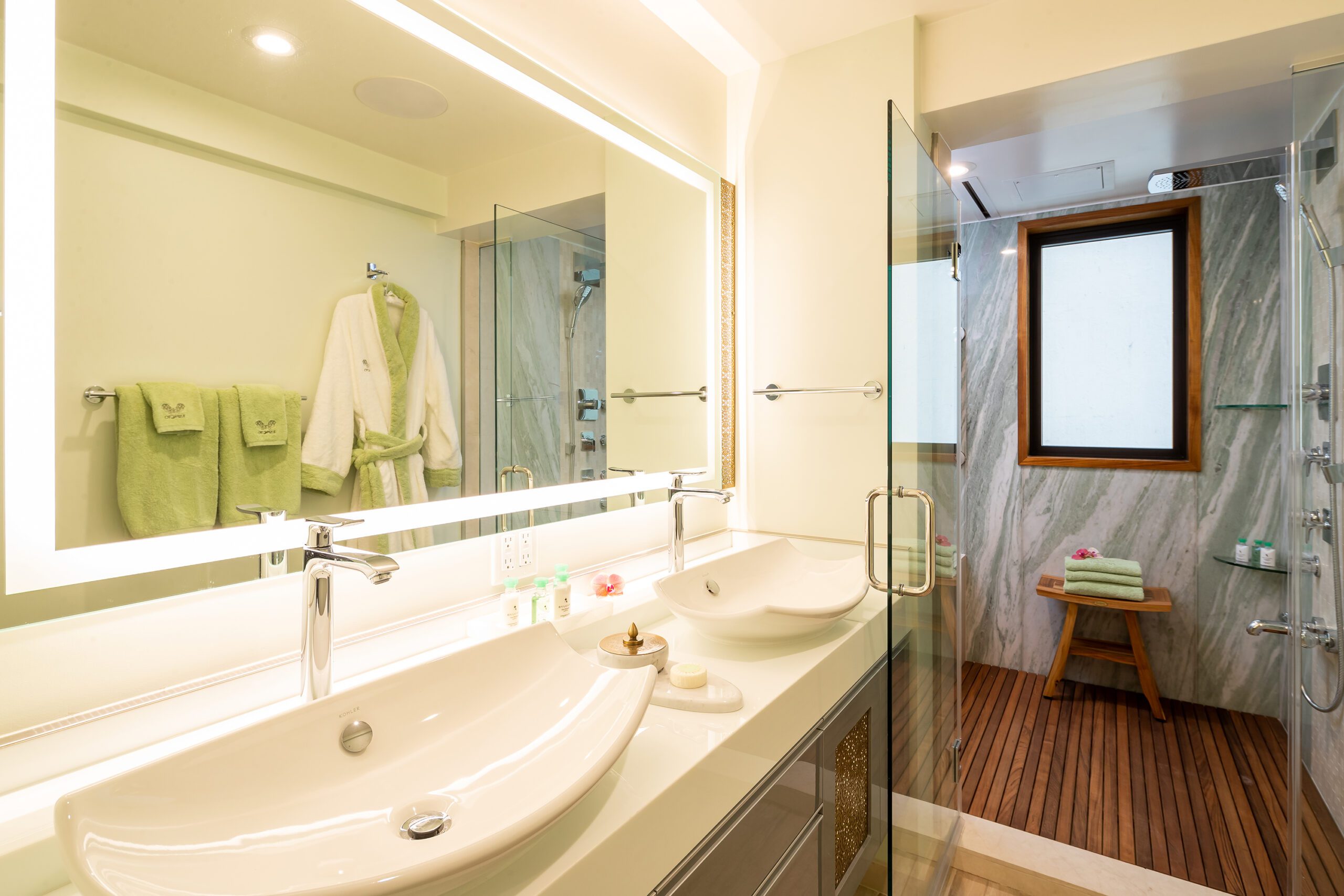 Bathroom with 2 sinks, mirror, and marble shower with sauna.