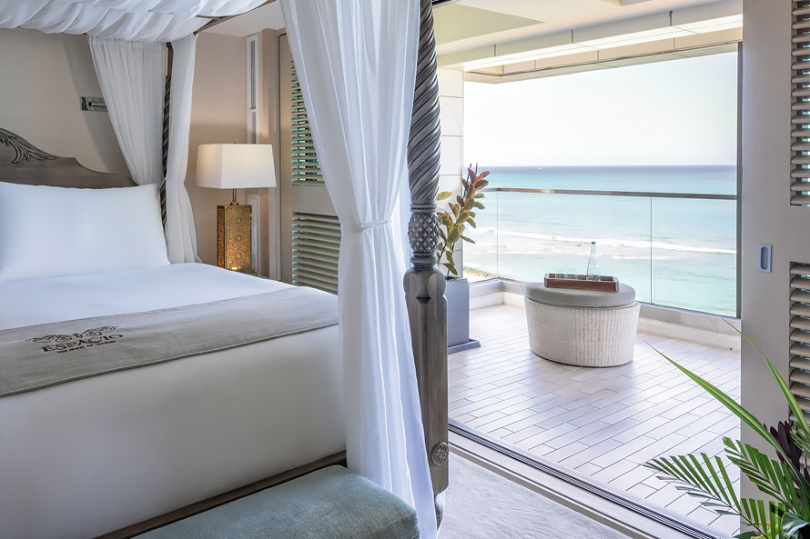 Master bedroom with canopy bed and sliding door to the balcony.